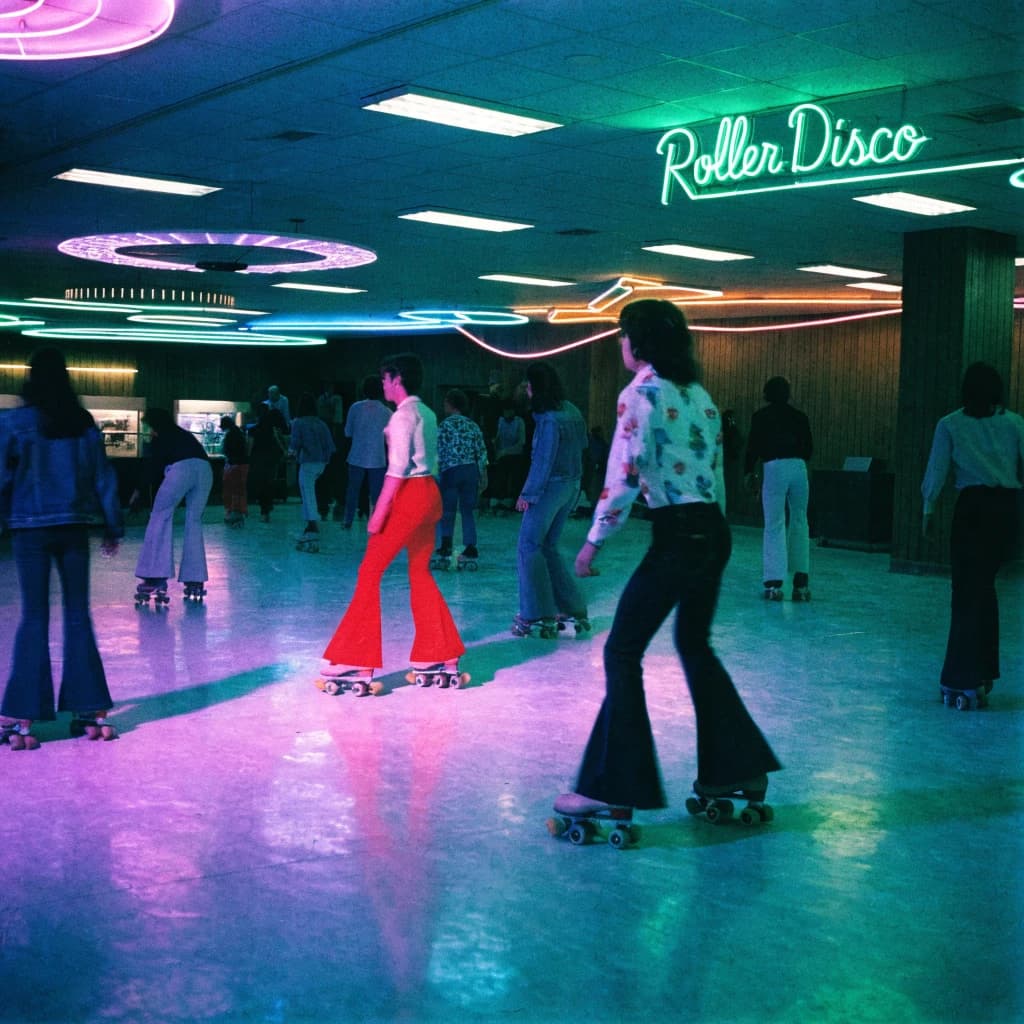 A 1970s roller rink crowd skates under neon, with a bit of fade and film grain.