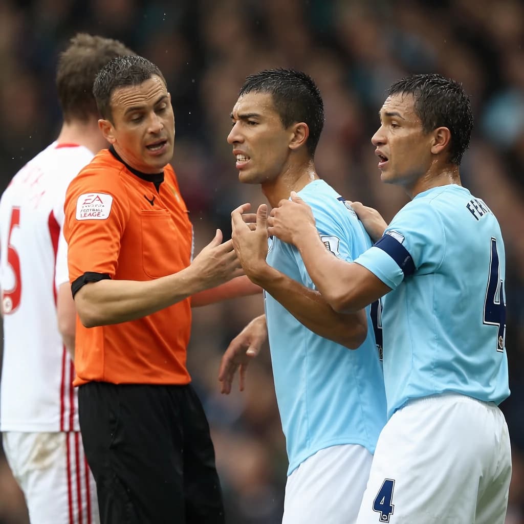 The soccer player clashes with the ref. It is thick and humid and the heat is getting to the players. His friend tries to pull him off before he causes any more trouble.