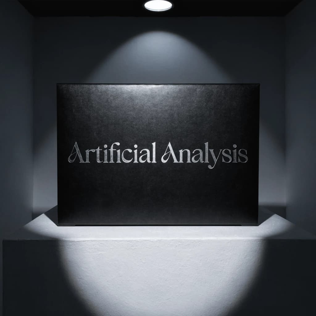 A premium matte black laptop-sized box rests on a pure white pedestal within a gallery space. Overhead, a single spotlight carves sharp contrast, leaving the edges in deep shadow. The brand name Artificial Analysis is embossed in silver foil, glinting faintly as though it were jewelry.