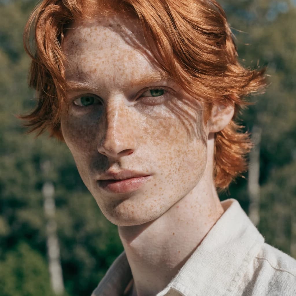 Shoot a natural light headshot of a red-haired man with freckles, green eyes.